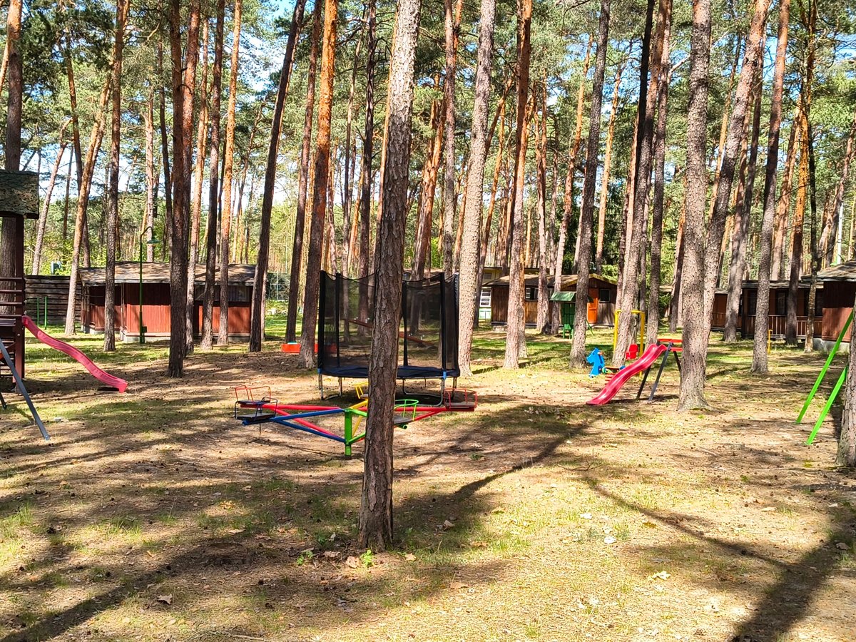 Plac zabaw dla dzieci na terenie ośrodka — huśtawki, zjeżdżalnie, trampolina